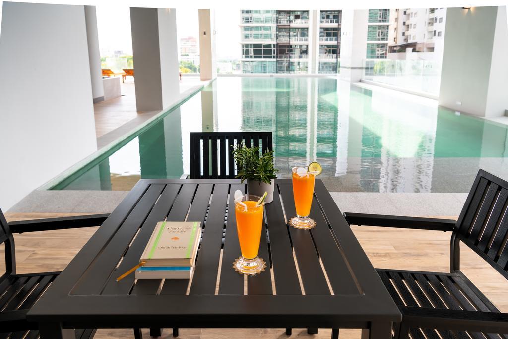 曼谷茉莉花59号酒店【SHA Plus+】 外观 照片 A poolside table and chairs